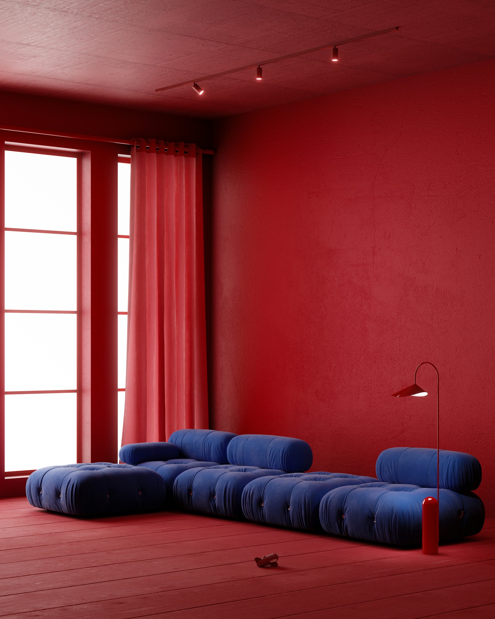 Living room with red walls, a blue sofa, and warm accent lighting.