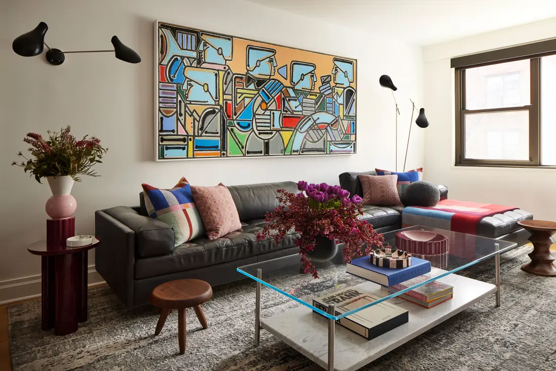 Cozy living room featuring floor and wall lamps illuminating a sectional sofa and coffee table.