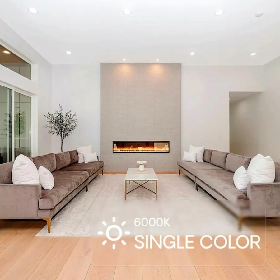 Modern living room featuring recessed lighting, tall ceiling, and two sectional sofas facing a central fireplace.