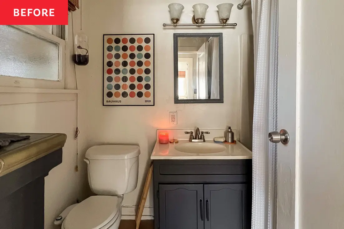 Small bathroom with a mirror and a countertop, featuring a candle for temporary lighting.
