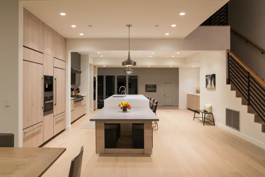 Modern kitchen with warm ambient lighting highlighting the sleek cabinetry and central island.