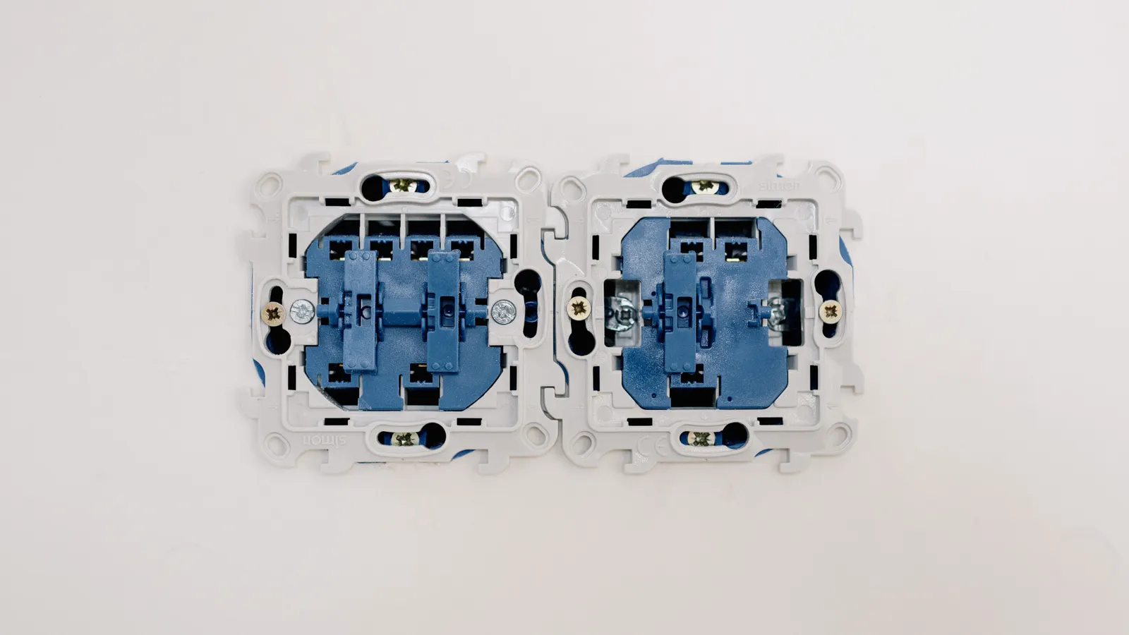 Open electrical switches showing wiring inside a wall box.